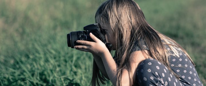 girl taking photo in field with best intermediate camera