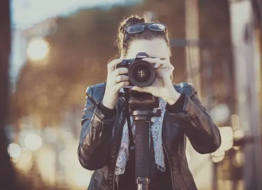 girl photographing on a mirrorless camera with bohek background